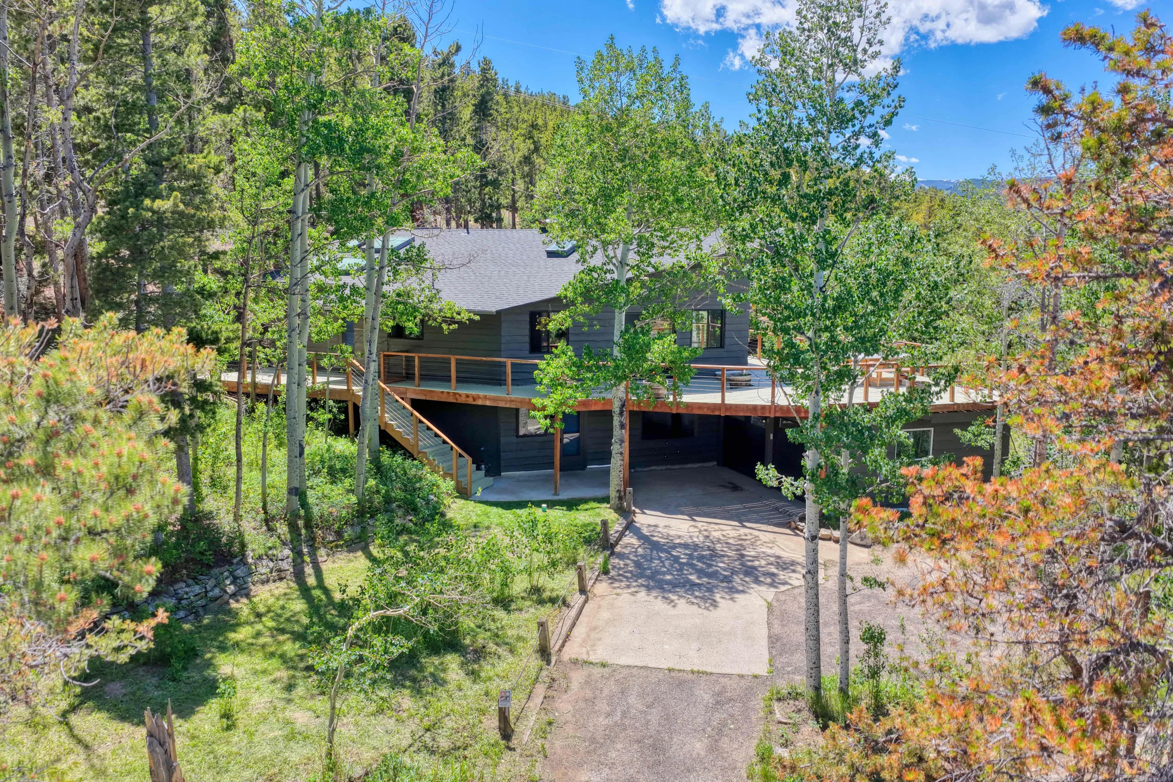 Drone real estate photographer image of a Denver mountain home surrounded by trees