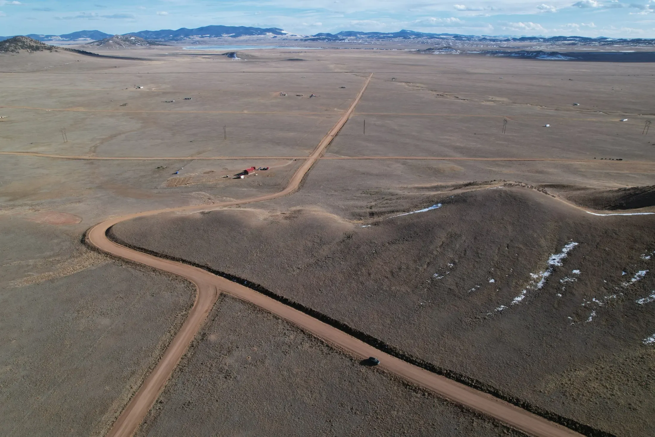 Drone photo of vacant Colorado acreage with open terrain and surrounding land context