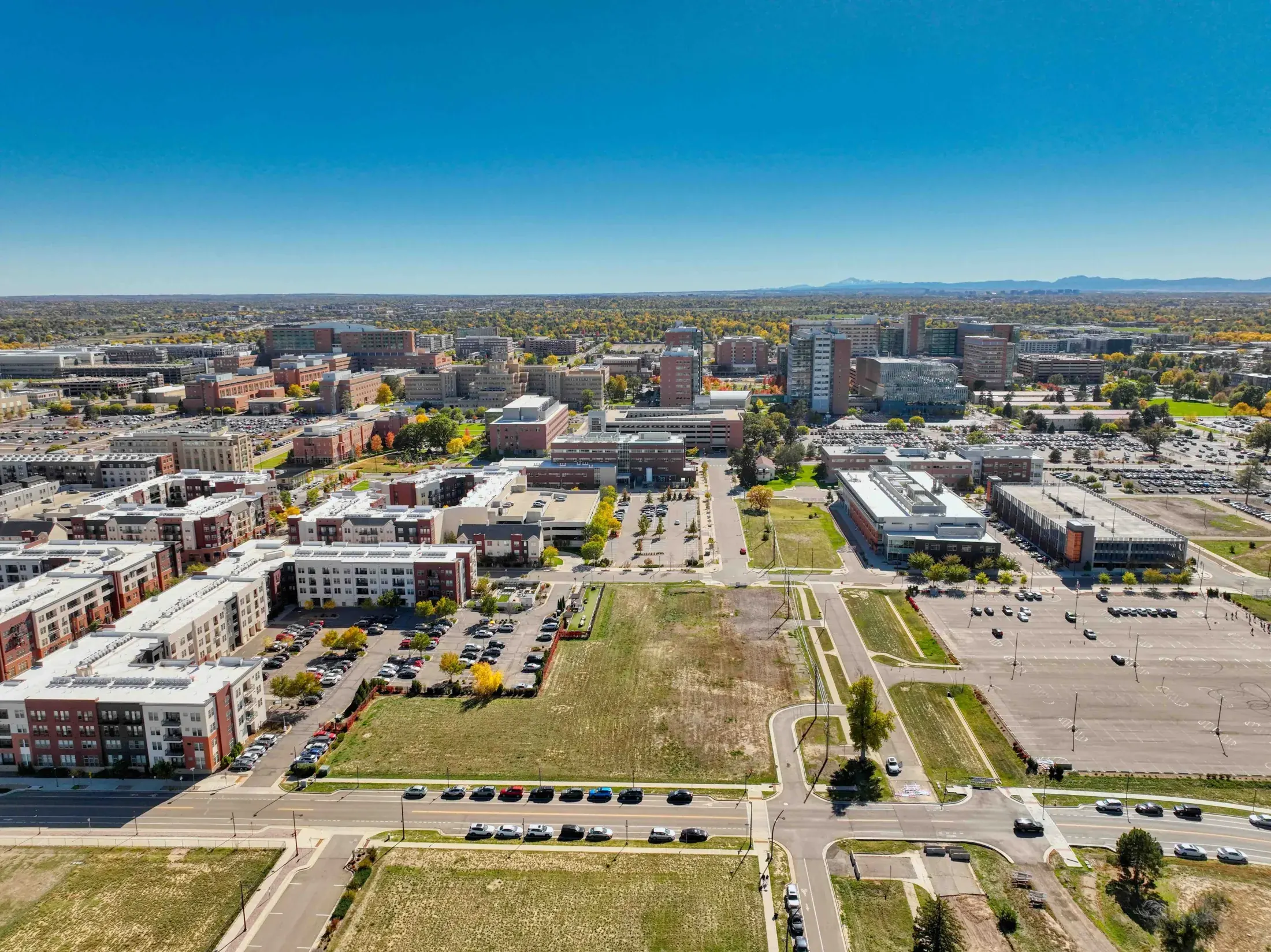 Drone photo of vacant land listing with roads, terrain, and surrounding property context